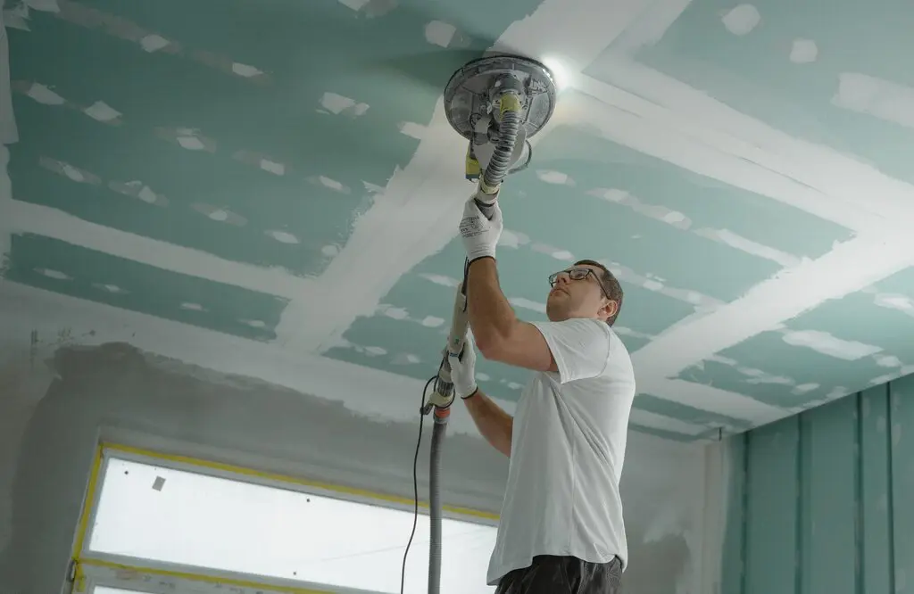 man finishing repair after ceiling leak