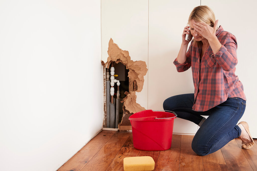 Middle Aged Woman With A Burst Water Pipe Phoning For Help