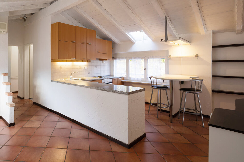 Vintage kitchen with wooden furniture and terracotta tile floor